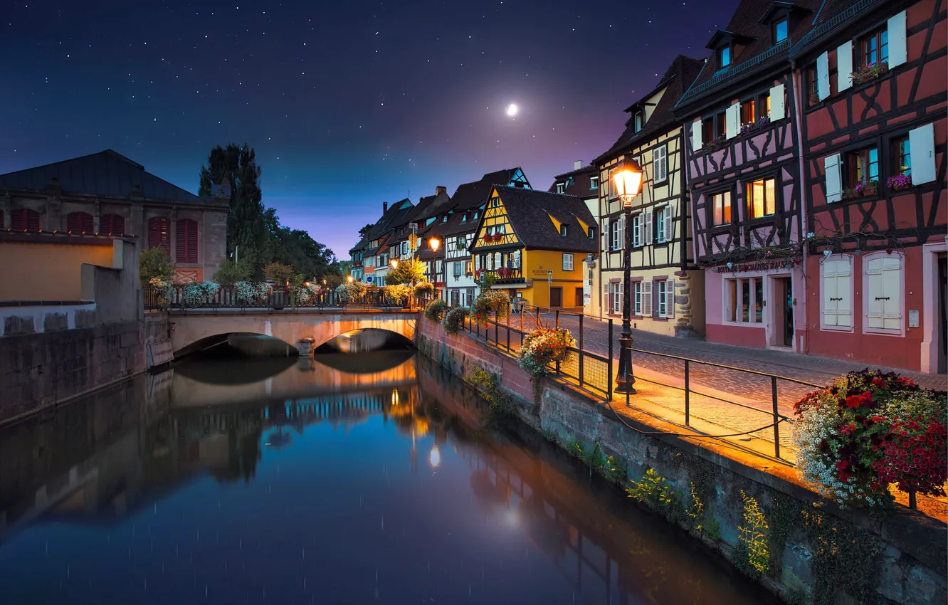 Фото обои ночь, город, река, луна, Франция, дома, звёзды, освещение, канал, мостик, набережная, France, Colmar, Кольмар